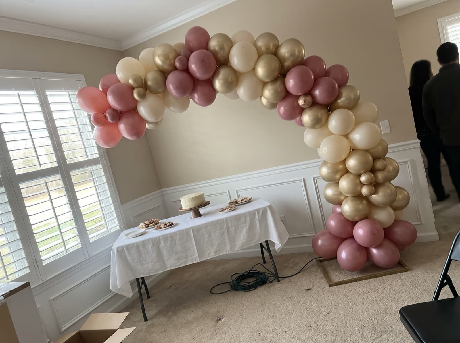 Organic balloon arch in dusty rose, cream and champagne gold over a dessert table at a Charlotte birthday party