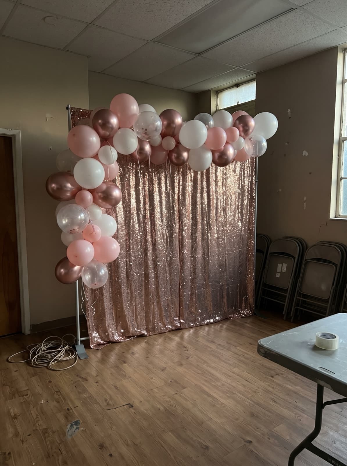 Rose gold shimmer wall backdrop with a balloon garland