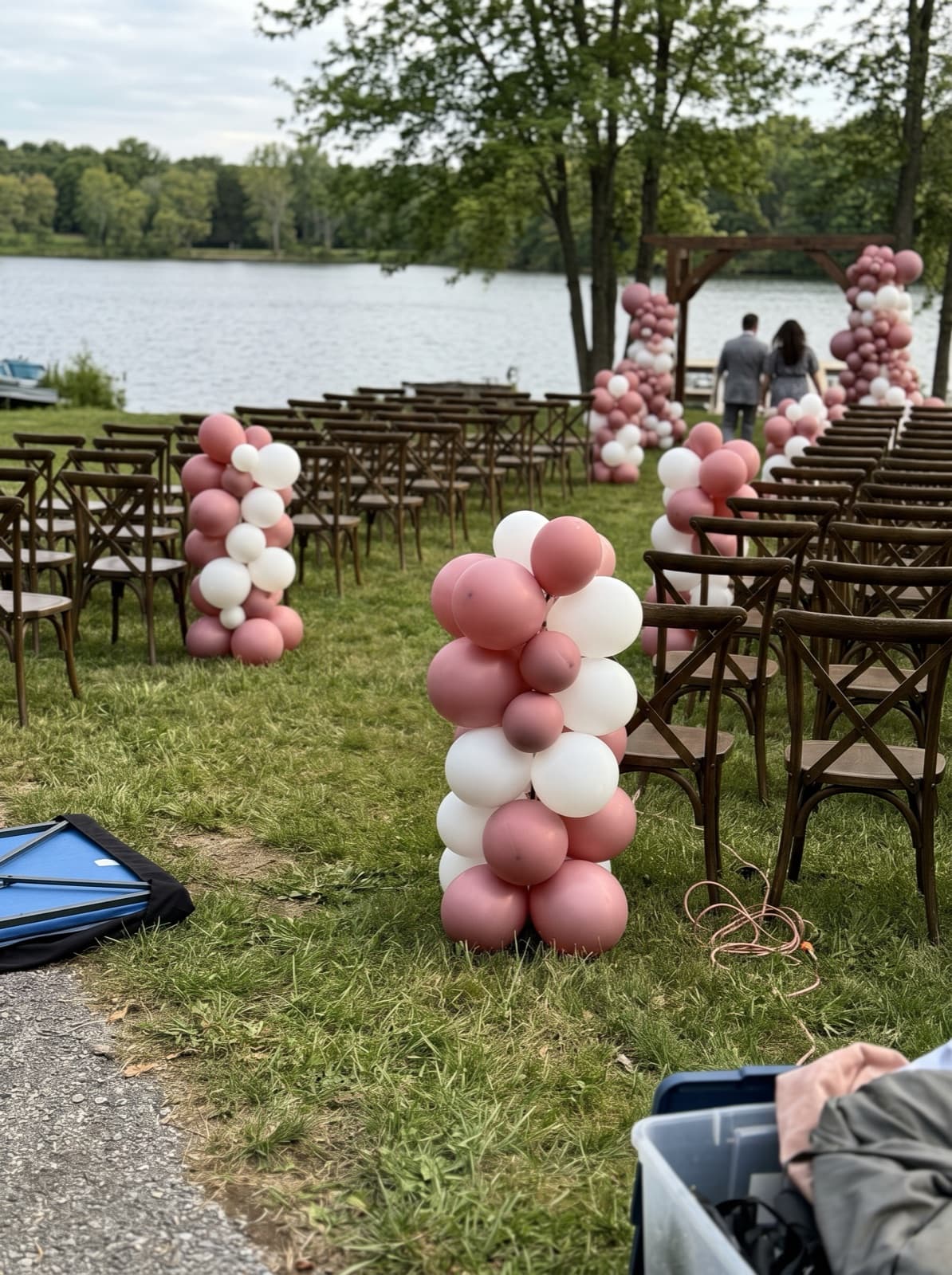 Organic balloon columns lining an outdoor wedding aisle