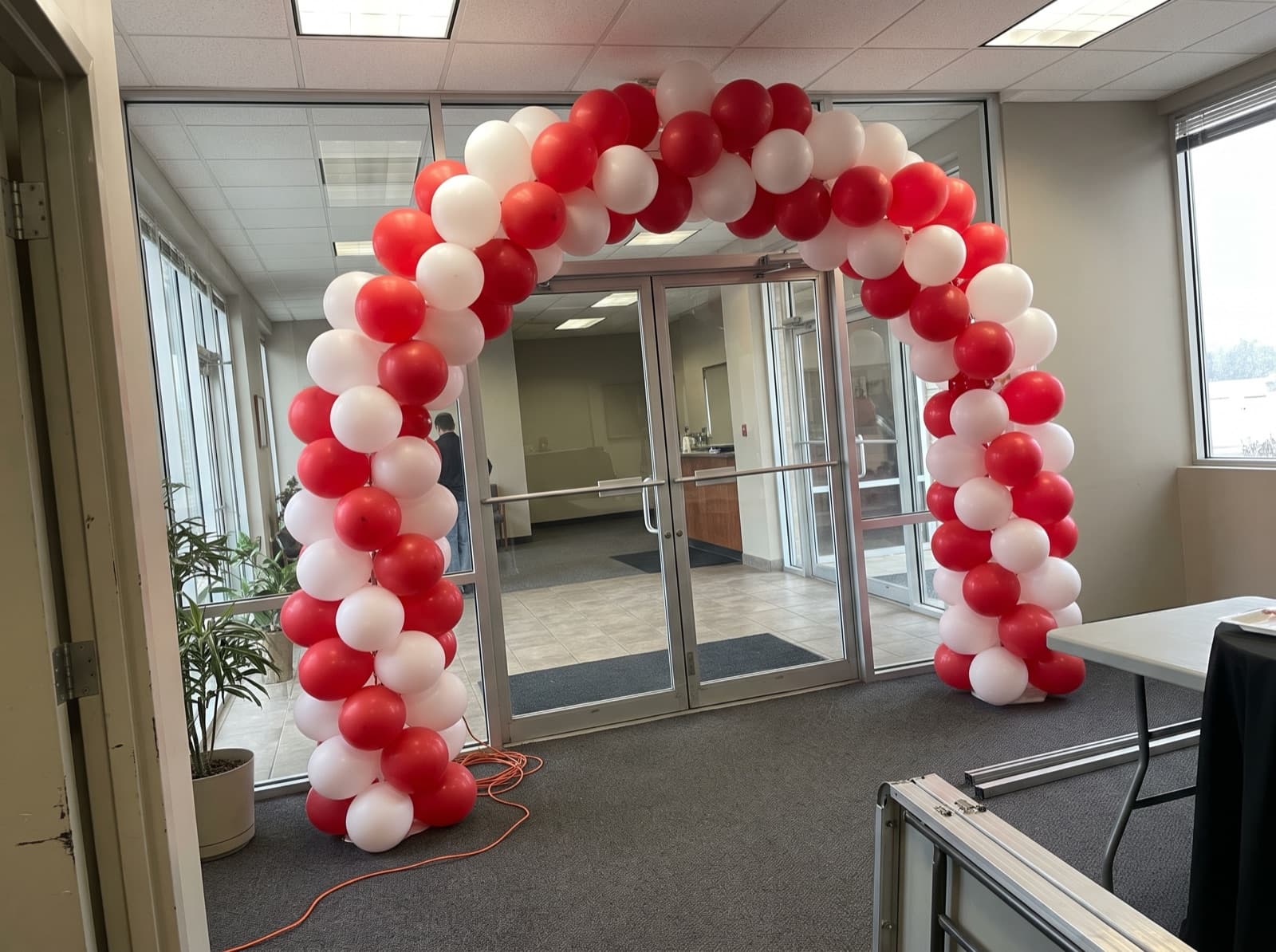 Balloon columns joined by a red and white arch