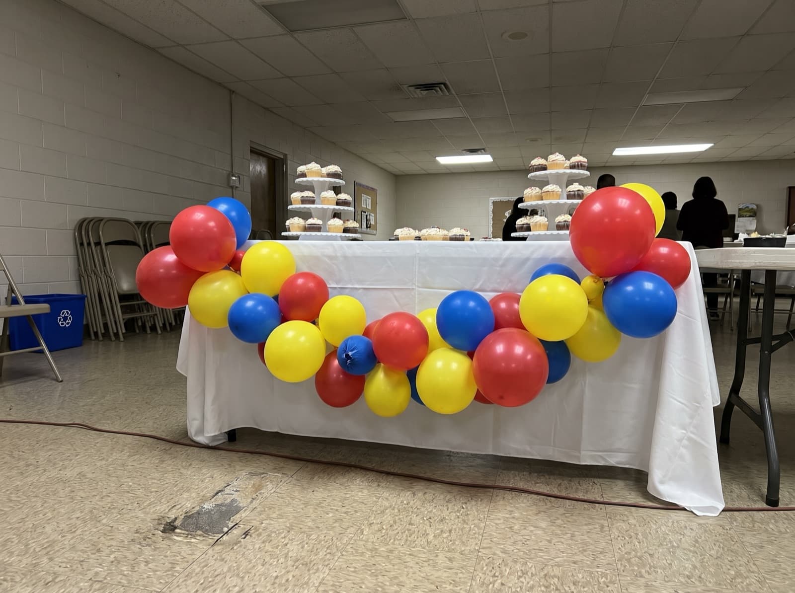 Bright balloon garland draped across a cake table