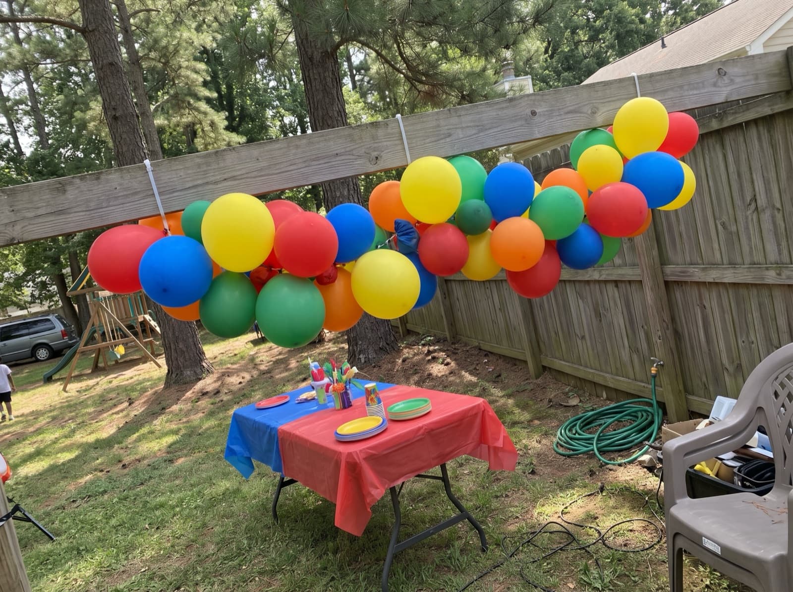 Balloon garland on a wooden backyard fence