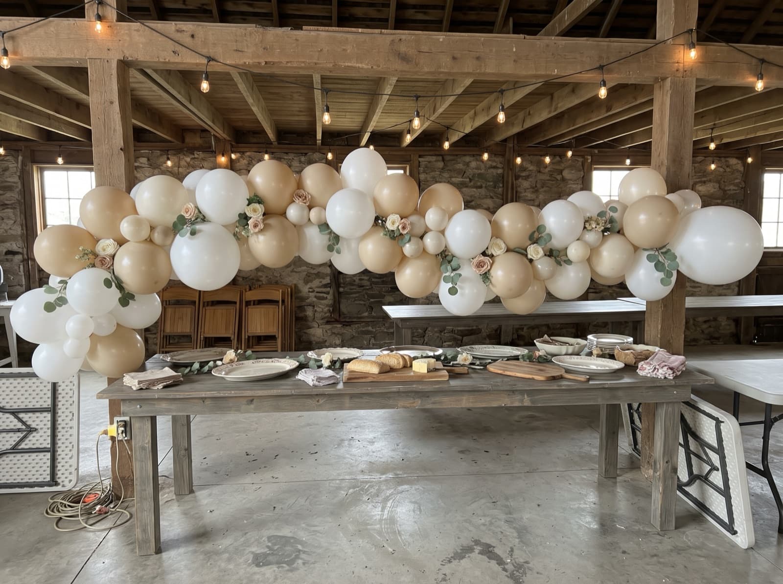 Balloon garland with eucalyptus and silk flowers along a buffet