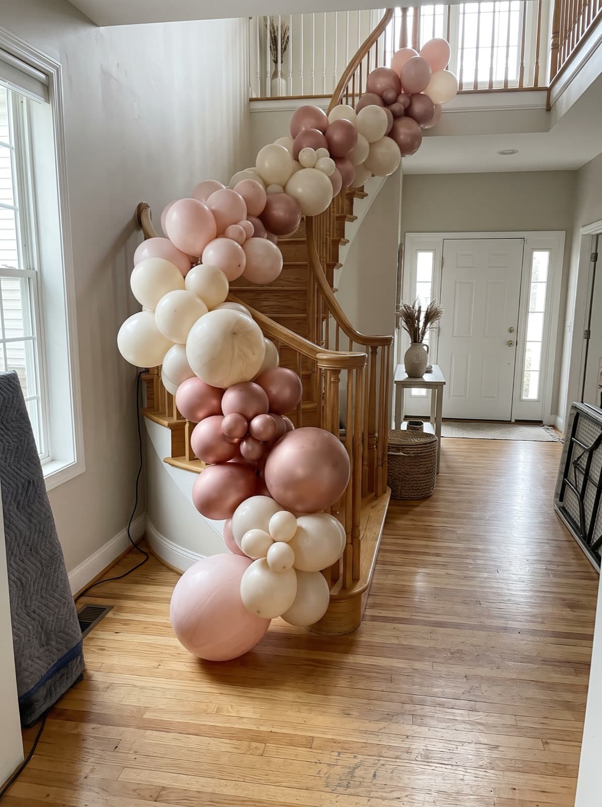 Balloon garland down the banister of a two-story foyer staircase