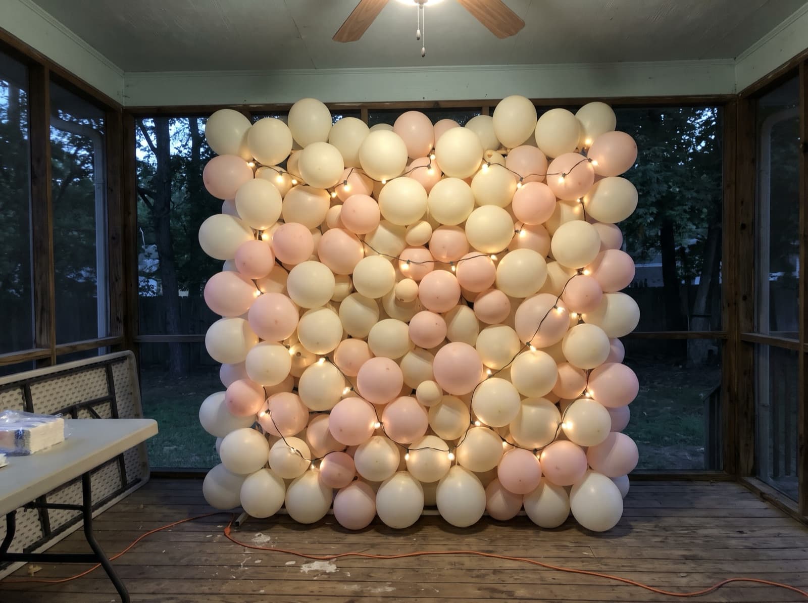 Balloon wall with string lights for an evening party